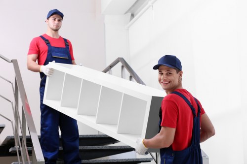 Professional flat removals in Stjamess with movers carrying boxes from an apartment building